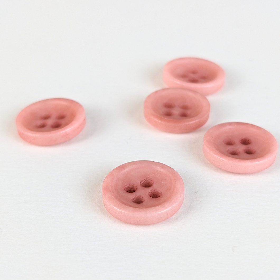 12mm four hole pink corozo buttons on white background