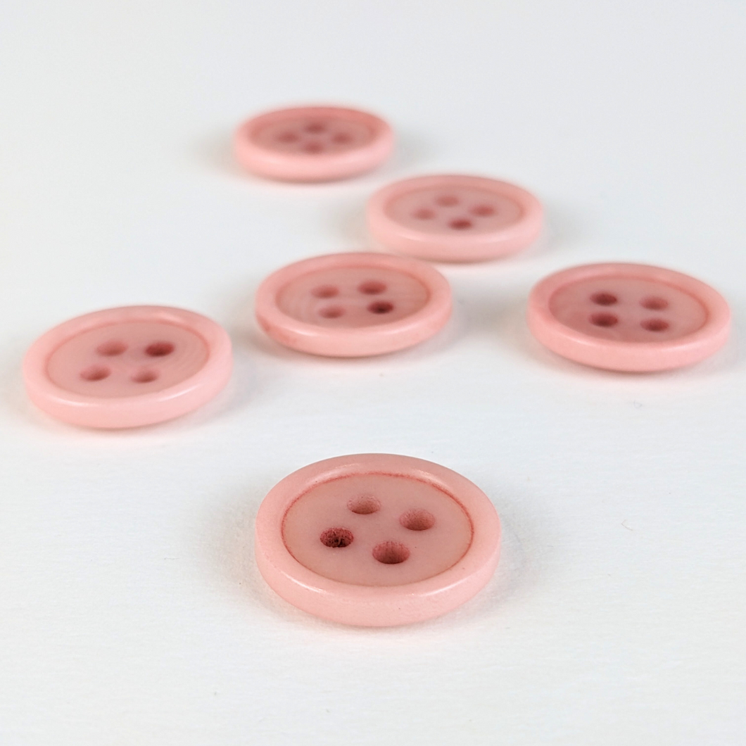 15mm four hole pink corozo buttons on white background