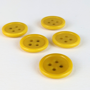 15mm four hole yellow corozo buttons on white background