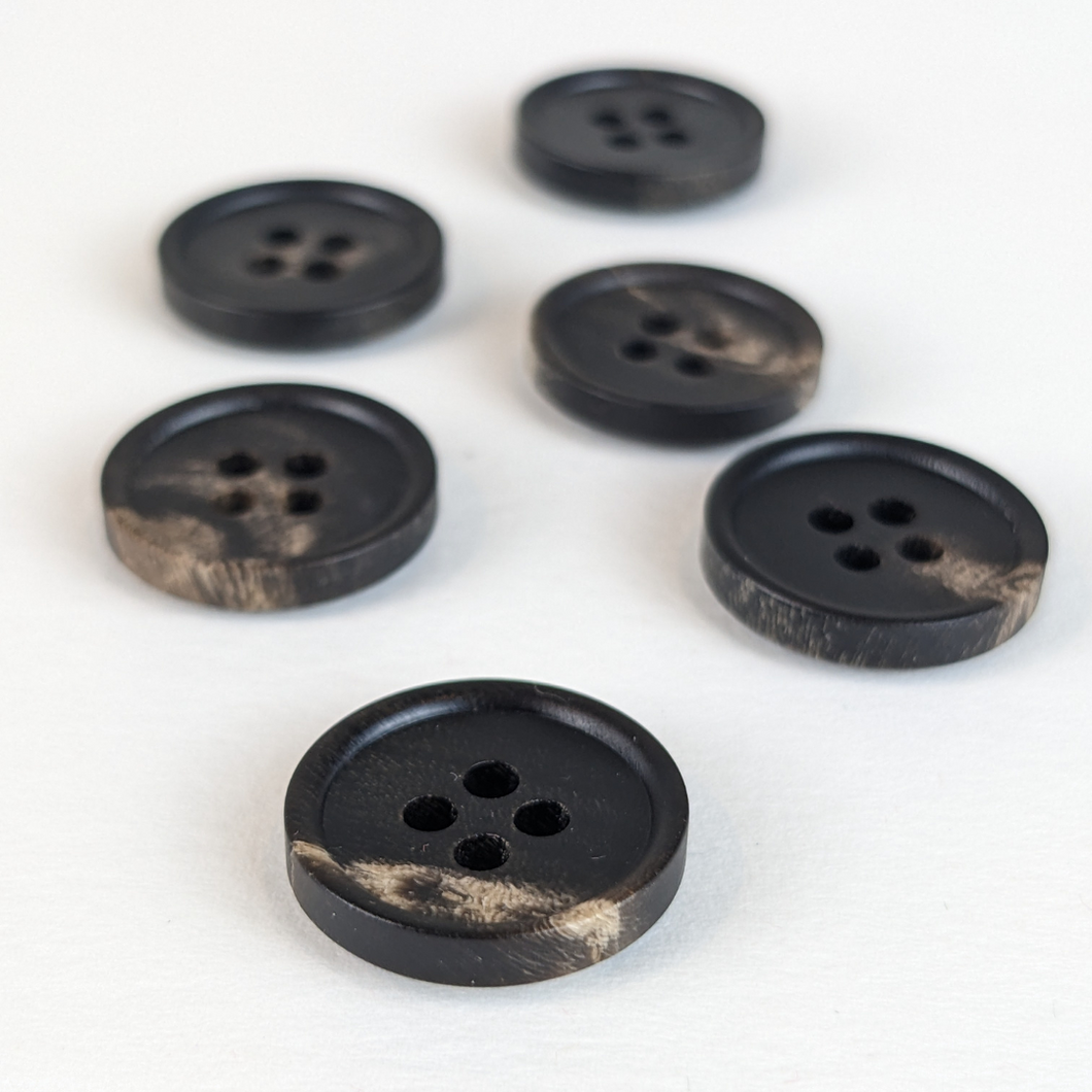 15mm four hole black horn buttons with unique natural cream and brown markings on white background