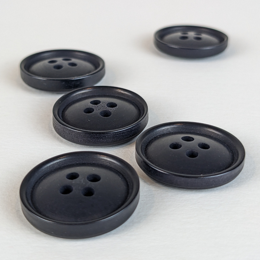 21mm four hole black corozo buttons on white background