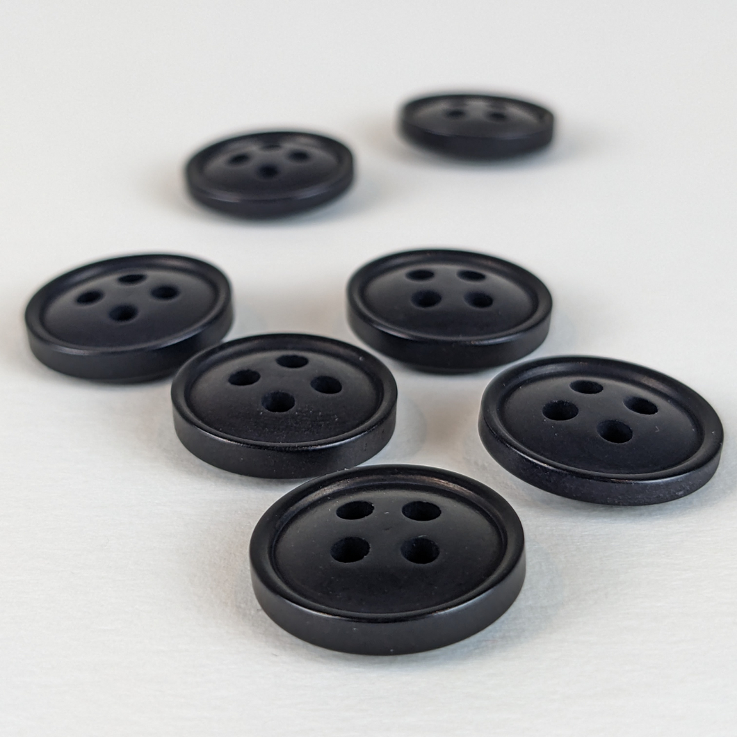 15mm four hole black corozo buttons on white background