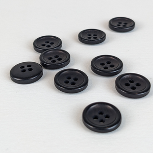 12mm four hole black corozo buttons on white background