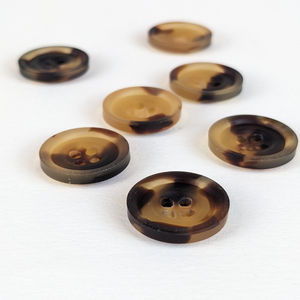 15mm four hole faux tortoise shell casein buttons with unique natural brown and black markings on white background