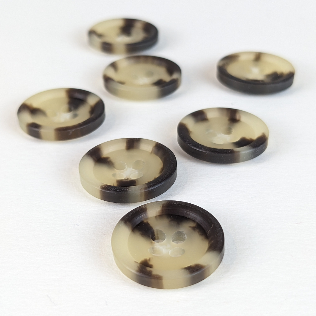 15mm four hole cream casein buttons with unique natural cream and black markings on white background