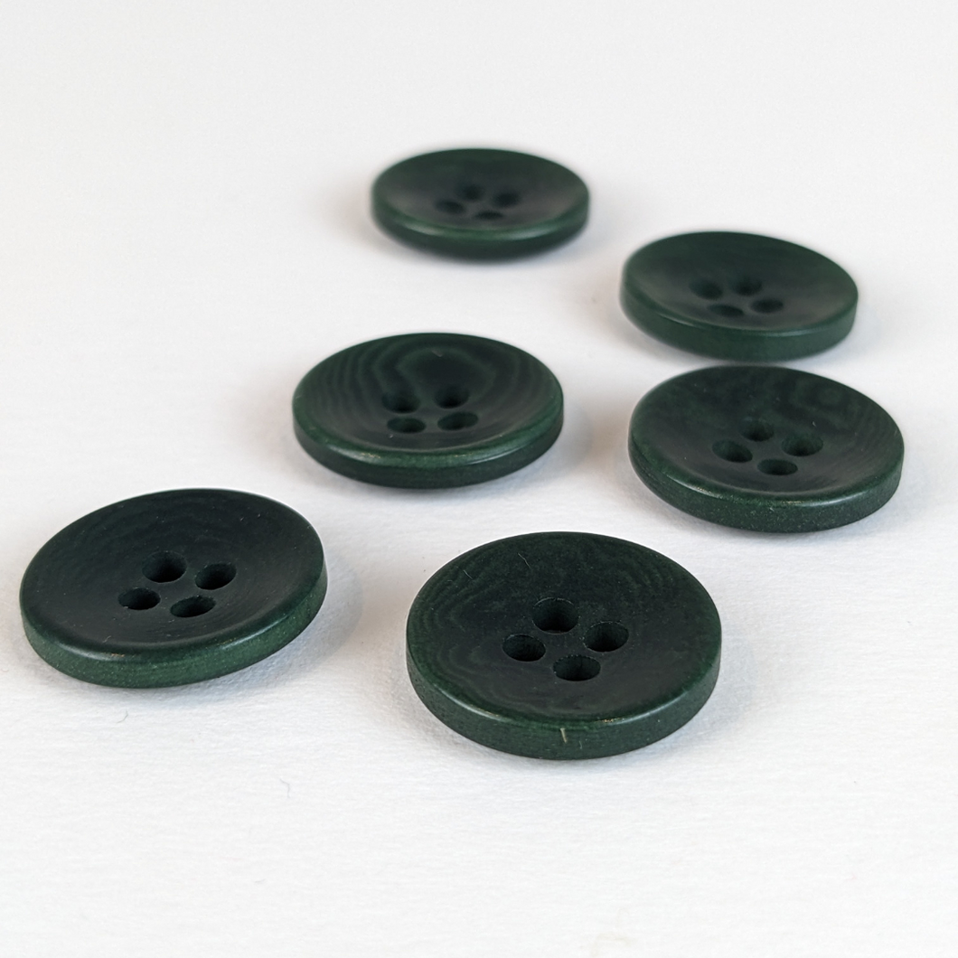 15mm four hole dark green corozo buttons on white background