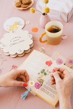 Load image into Gallery viewer, Colorful flower press crafts in action with a wooden press, tea, and botanical elements on a pink table.
