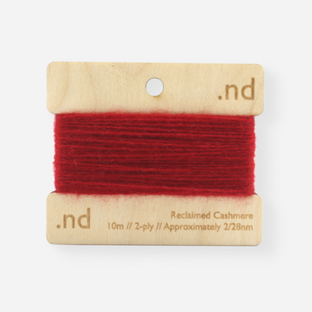 Deep red reclaimed / recycled 100% cashmere mending yarn. 10m wound horizontally onto bespoke laser cut and branded ply. Approximately 2/28nm. perfect weight for visible and invisible mending, darning and Swiss darning knitwear repairs. Made by Second Cashmere at Bawn Glasgow