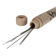 Merchant and Mills Millner sewing needles spilling out of hollow wooden cylinder tube.