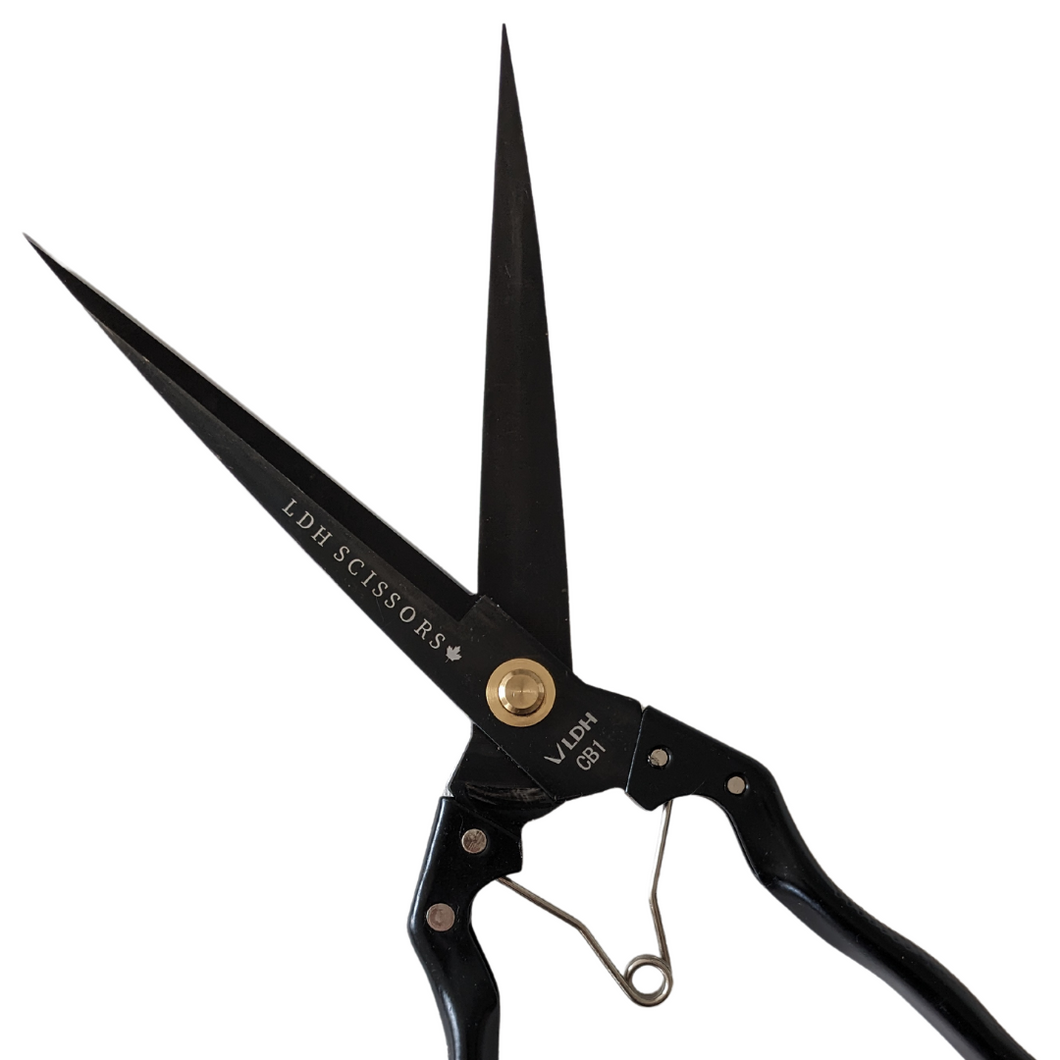 Sprung handle batting fabric shears in black, branded with LDH company logo. Open blade diagonal lay